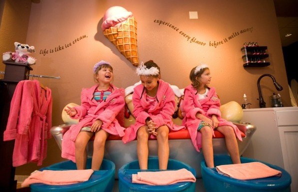 키즈 don pink robes and tiaras at the ice cream-themed Scooops Spa at Great Wolf Lodge.
