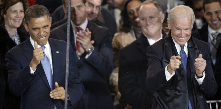 副 President Joe Biden gives the thumbs up and the finger point as he and President Barack Obama react during the inaugural parade on Pennsylvania Avenue near the White House on Monday.