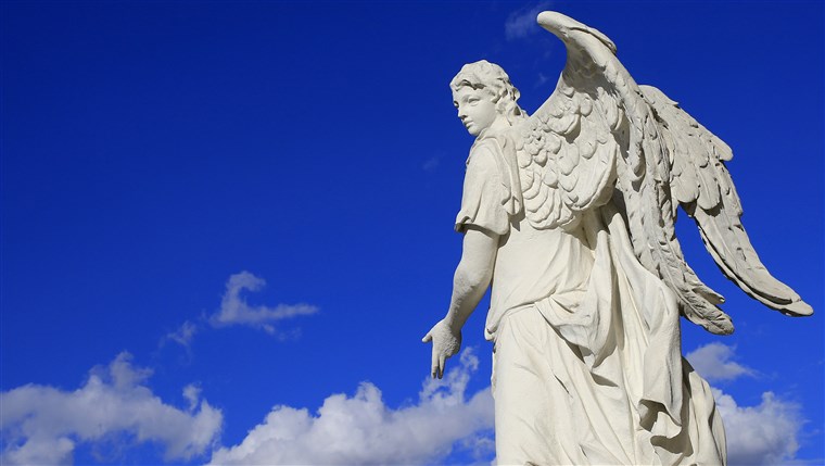 그만큼 statue of an angel is seen at the Karlskirche (St Charles's church) on a sunny day in Vienna as clouds are seen in the sky on April 13, 2013. The ...