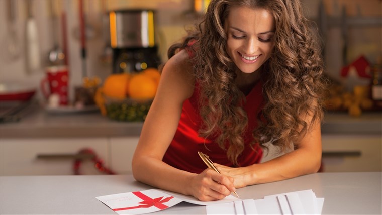 행복 young housewife signing christmas postcards in kitchen; Shutterstock ID 158618495; PO: TODAY.com