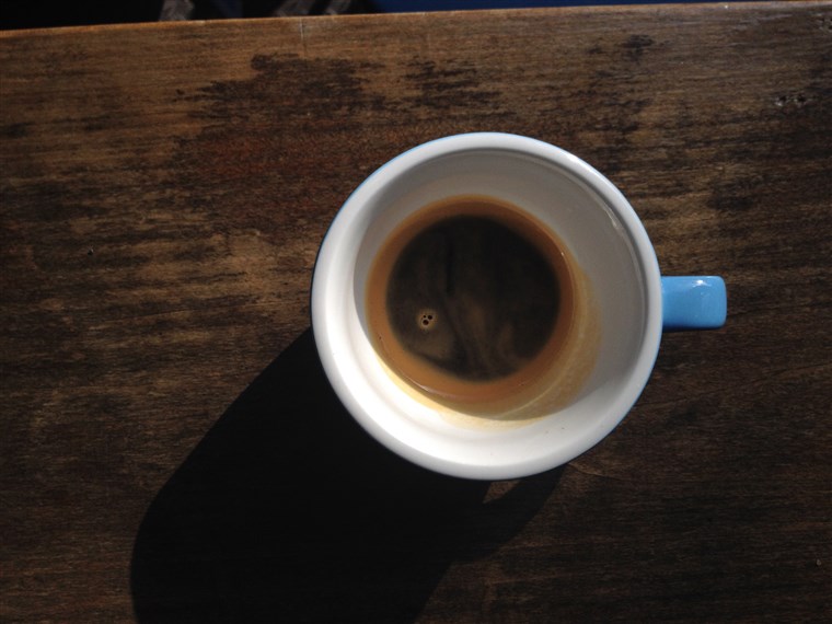 注ぐ espresso into a large coffee cup