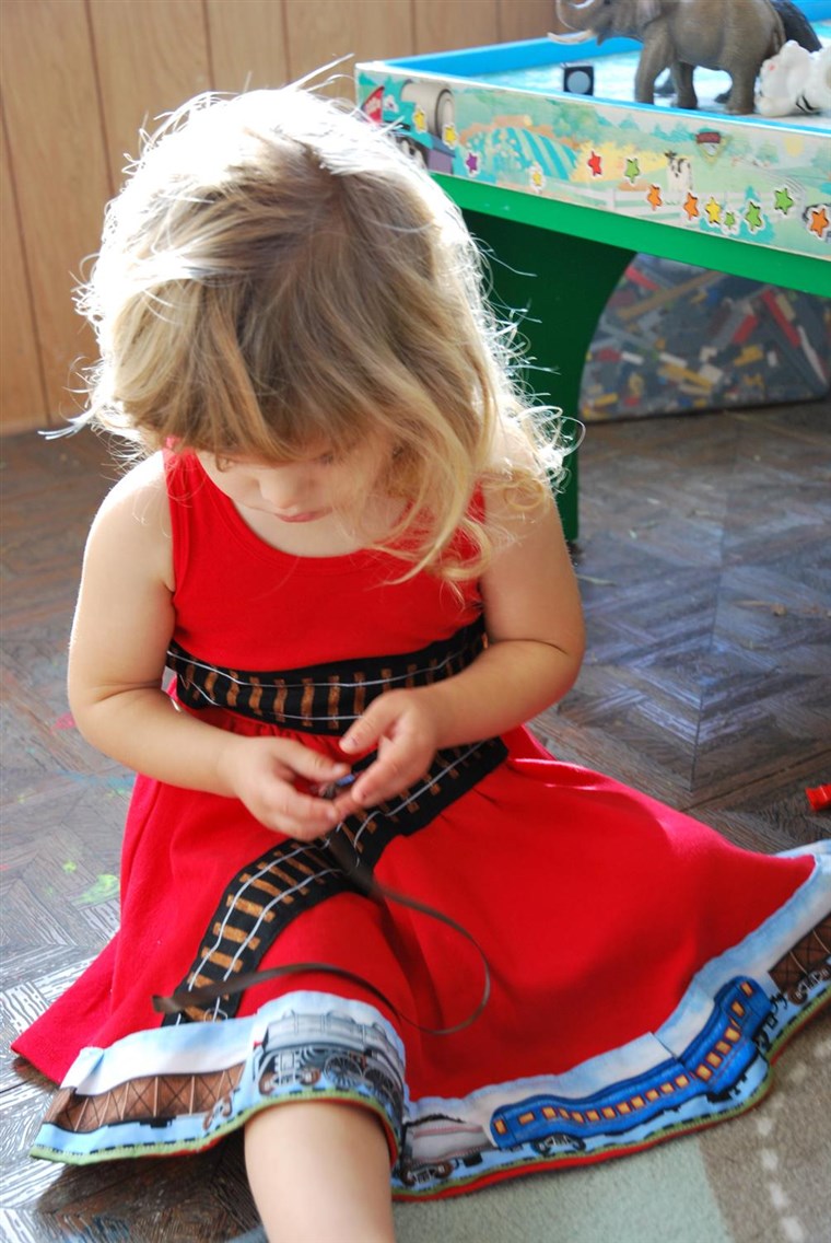 Model Sienna plays with her train-themed dress.