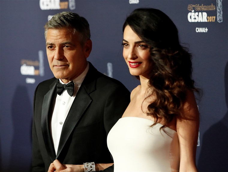 画像： FILE PHOTO: Clooney and his wife Amal pose as they arrive at the 42nd Cesar Awards ceremony in Paris