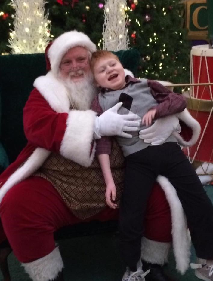 Maggie Dunham says her son, Will, takes longer than most to get set up for his photo due to his use of a wheelchair, but never feels rushed by Santa Scott and his team.