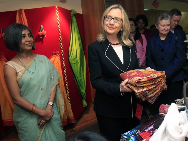 Dia might be going easy on the makeup, but she still has an eye for colorful fashion: Clinton holds a sari in Kolkata, India, on May 6.