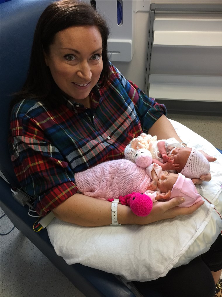 캣 Smith poses with her twin daughters, born at just 28 weeks. 