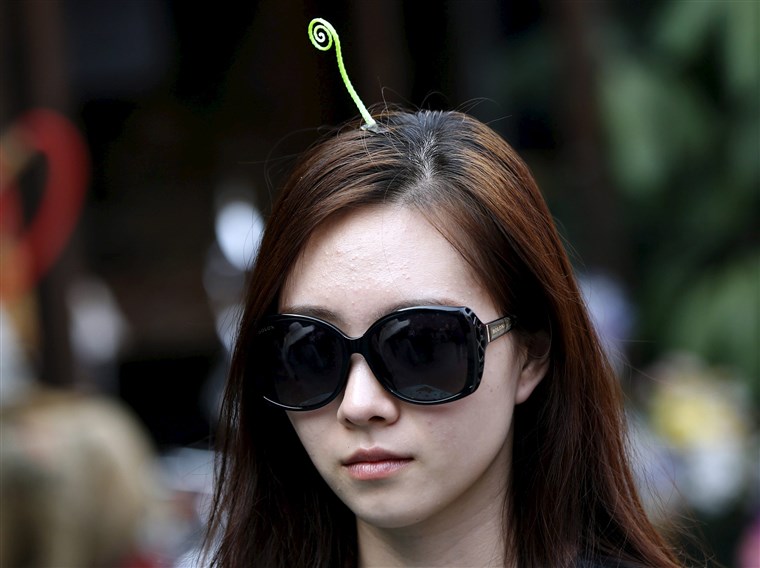 UN woman wearing a sprout-like hairpin makes her way on Nanluoguxiang street in Beijing