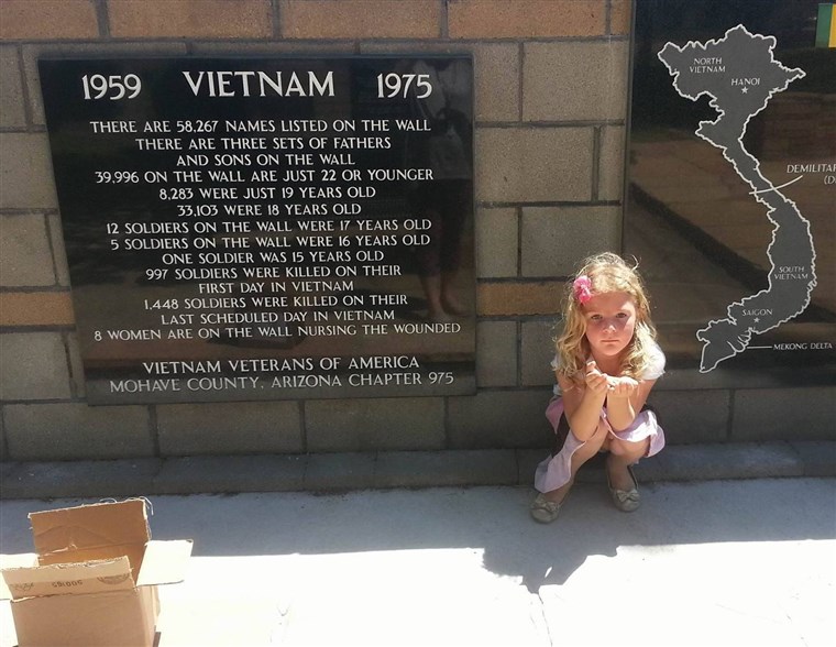 Brendi Phillips' 4-year-old daughter, Serenity Hopkins, prepares to hide a painted rock at a memorial site.
