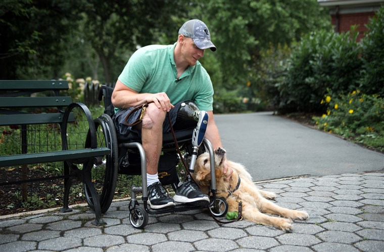 米国。 Navy Corpsman Joe Worley and his service dog, golden retriever Benjamin.