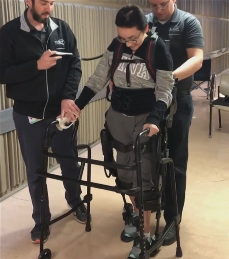 A robotic exoskeleton has helped her as she learns to walk again. 