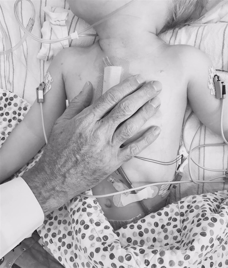 博士 Thomas Spray's hand over Finn's heart, moments after surgery.