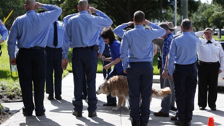 브르타뉴 the last surviving search and rescue dog from 9/11 is walked by her handler Denise Corliss past a flank of members of the Cy-Fair Volunteer Fire Department