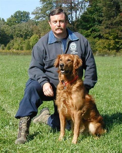 테리 직물 Trepanier, a career firefighter, is pictured in 2002 with his search dog, Woody.