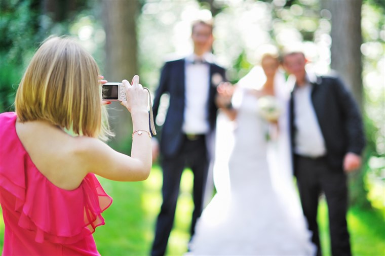 소녀 photographing guests at a wedding.