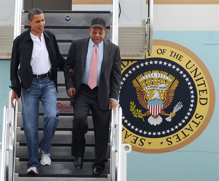 Presiden Barack Obama, left, escorts Hall of Famer Willie Mays, right, on his arrival at Lambert St. Louis International airport Tuesday, July 14, 20...