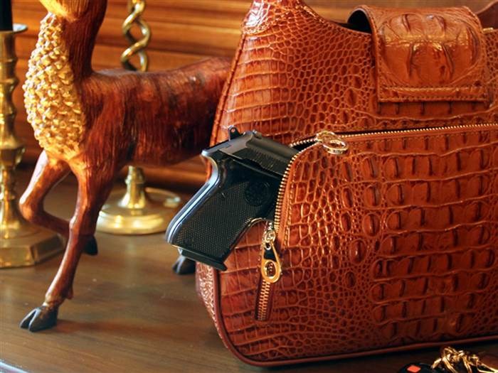 Questo crocodile-print leather hobo has a discreet compartment specially designed to conceal a firearm