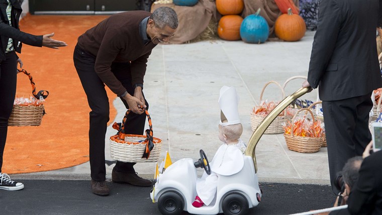 オバマ greets a young child dressed as the Pope