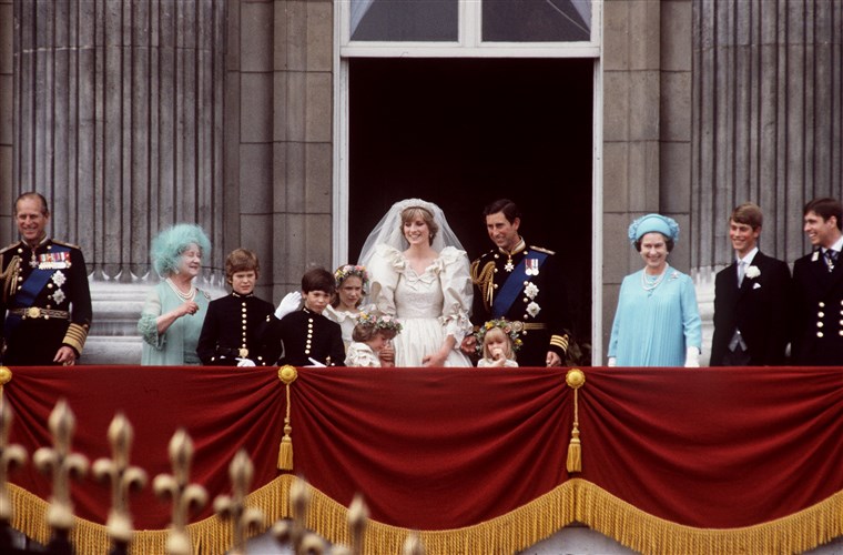 Principe Charles to Princess Diana wave to crowds outside of Buckingham Palace. Clemintine Hambro stands in front of the prince, to the left of Queen Elizabeth.