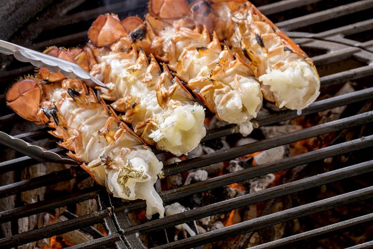 Lobster tails cooking over charcoal 