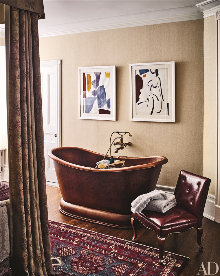 에이 copper pedestal tub makes a style statement in the master bedroom.