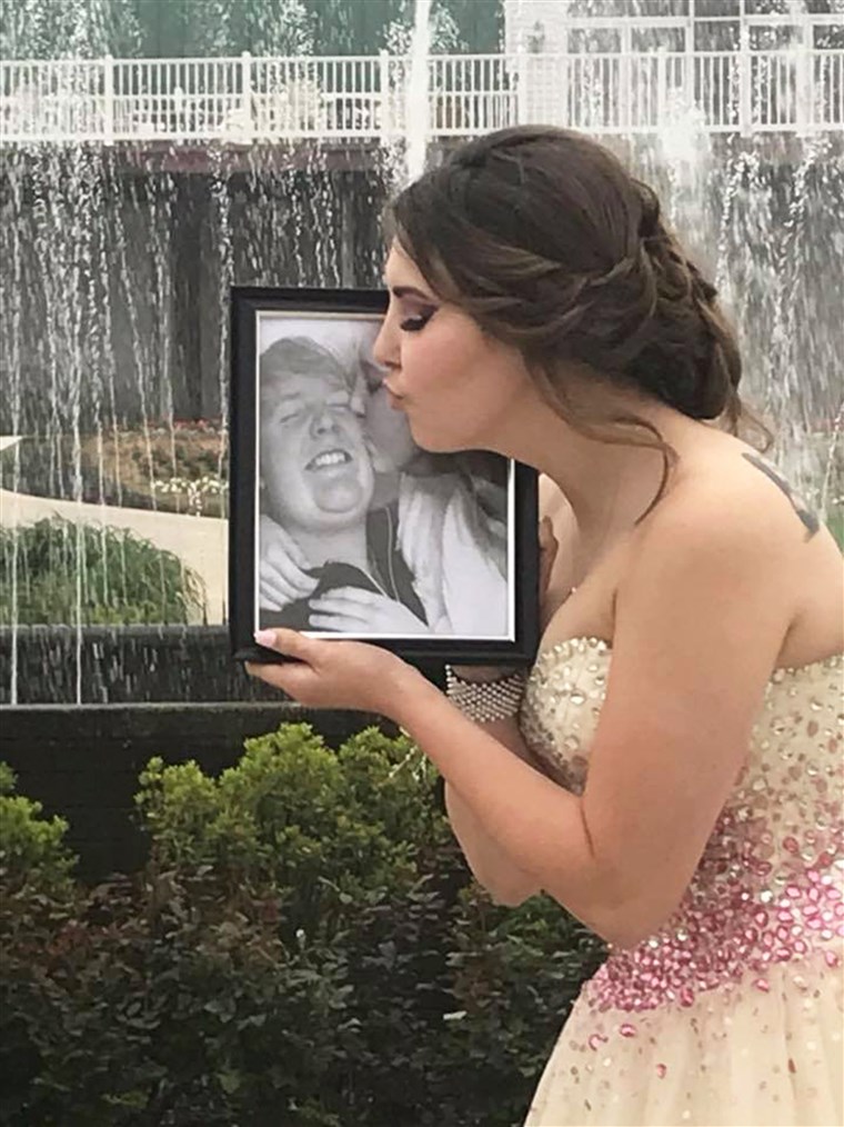 ケイリー offers a kiss to a photo of Carter on prom night. 