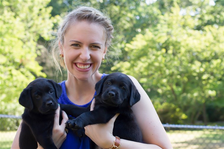 Olivia Poff poses with puppies from the litter.