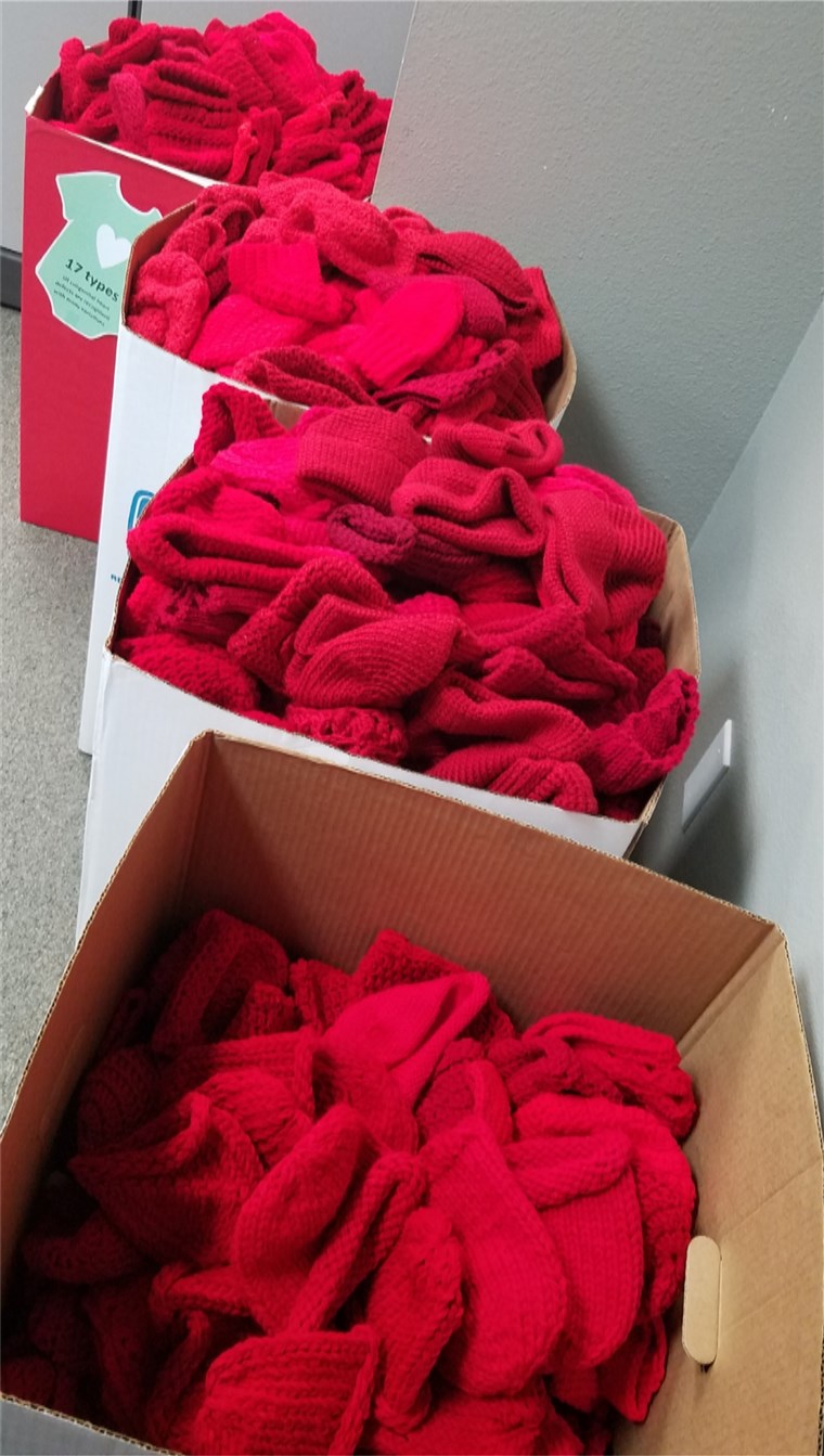 ボックス of red caps knitted for babies by volunteers