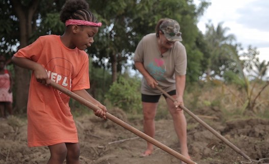 Pemain harpa and Missy working on the community garden they sponsor in Missy's birth village.
