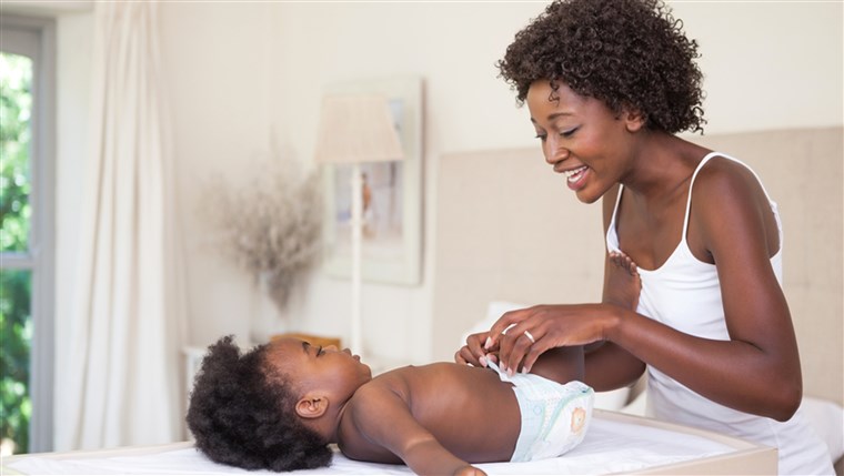 Contento mother with baby girl on changing table at home in the bedroom; Shutterstock ID 207022615; PO: TODAY.com