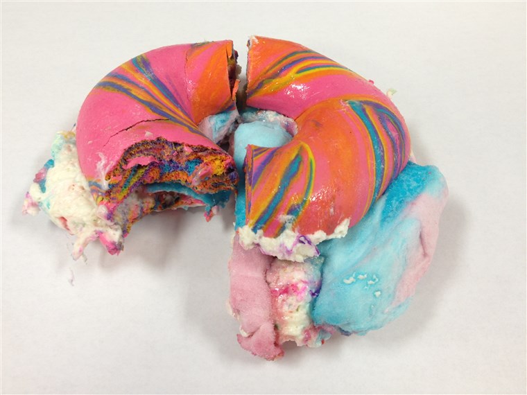 Pertama bite of Rainbow Bagel Stuffed with Funfetti Cream Cheese and Cotton Candy from Brooklyn's The Bagel Store